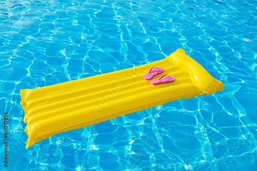 Beach summer holiday background. Inflatable air mattress, flip flops and hat on swimming pool. © nata777_7