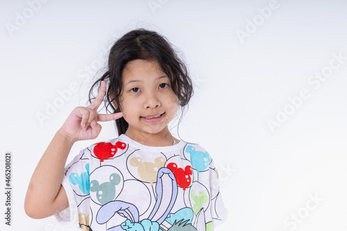 Portrait Asian kid girl she nice-looking cute attractive healthy. Make v-sign good mood isolated on white background in studio shot with copy space. © Chaiwat
