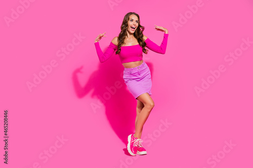Full length portrait of adorable cheerful girl look astonished empty space isolated on vivid pink color background