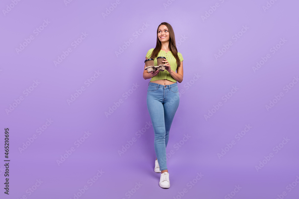 Full length body size view of pretty cheerful girl holding latte going free time isolated over purple violet color background Full length body size view of pretty cheerful girl holding latte going free time isolated over purple violet color background