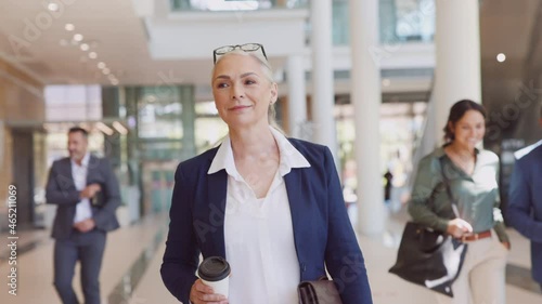 Senior businesswoman looking and smiling at camera while walking