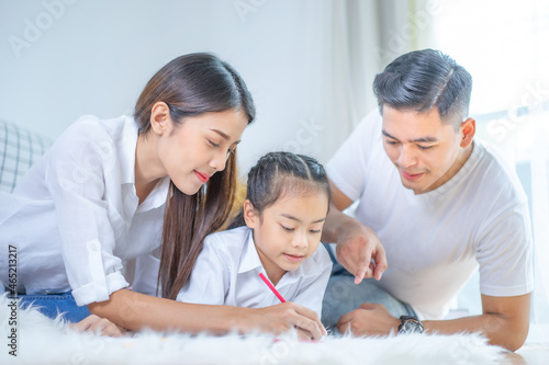 Happy family. Mother, father and daughters painting together. Adults helping to children girls. 