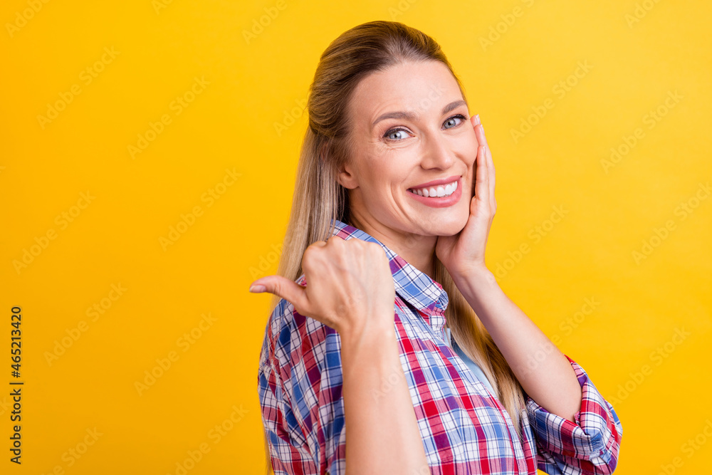 Profile photo of funny blond young lady index empty space wear plaid shirt isolated on yellow color background Profile photo of funny blond young lady index empty space wear plaid shirt isolated on yellow color background