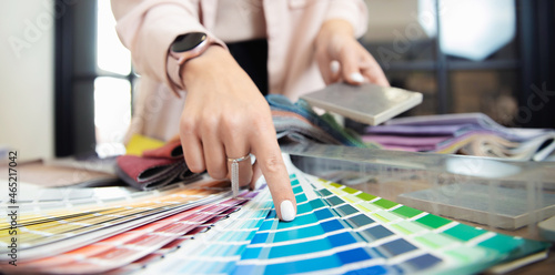 Banner hand of woman decorator, interior and graphic designer, architect is choosing catalogue colors ral for web project photo
