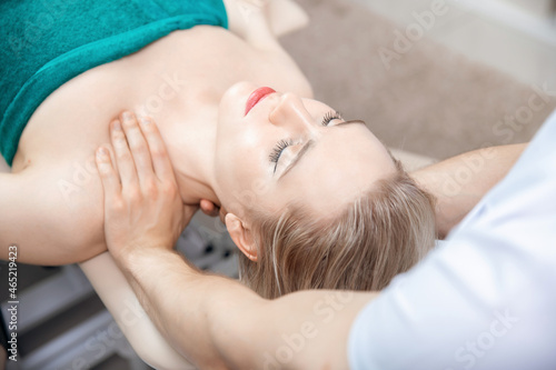 Therapist osteopathy working sports massage with shoulders of woman athlete