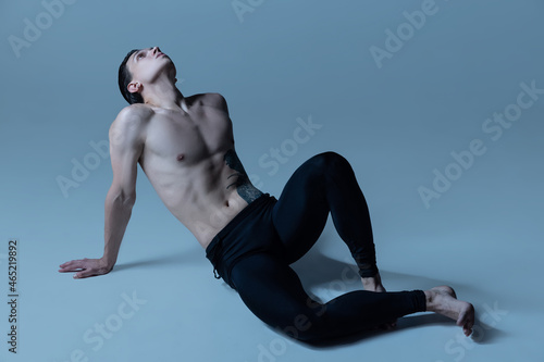 One handsome man, male ballet dancer in art performance isolated on old navy studio background. Art, motion, action, flexibility, inspiration concept.