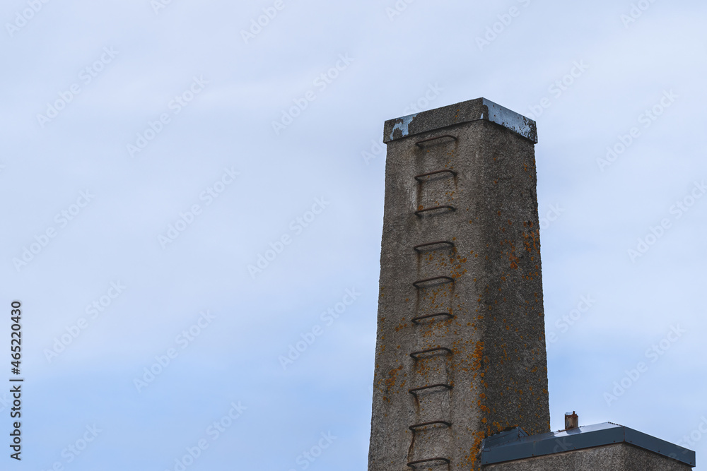 A ladder on a chimney with a blue sky as a background, copy-space