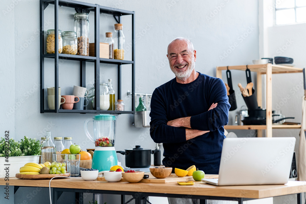Man with arms crossed standing at kitchen counter Man with arms crossed standing at kitchen counter