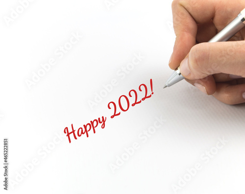 Hand writing "Happy 2022!" on white sheet of paper.