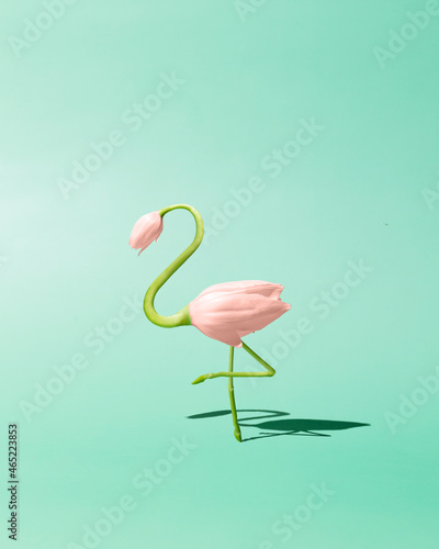 Contemporary art still life concept. Flamingo made from pink tulip flowers. Spring and summer green background. Flamingos Lover