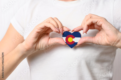 Flag of the Colorado in the shape of a heart in the hands of a girl. Love Colorado. The concept of patriotism