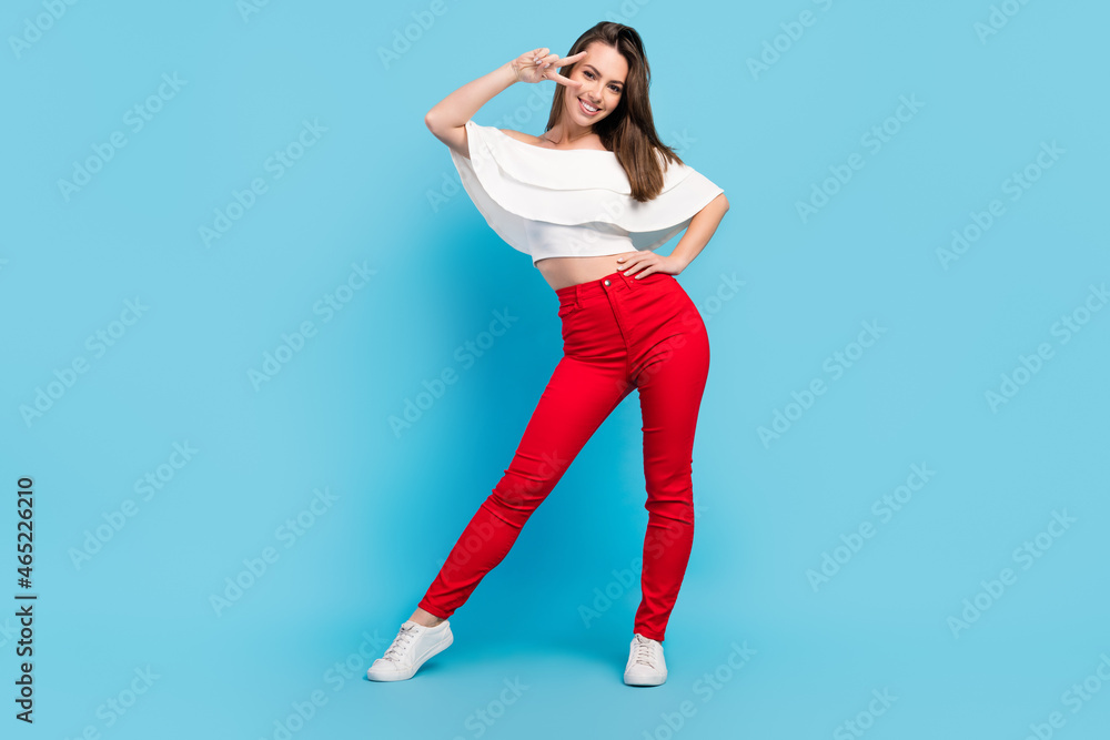 Full size photo of impresssed brunette young lady show v-sign wear blouse jeans isolated on blue color background