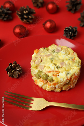 Christmas concept of tasty food with Olivier salad on red background