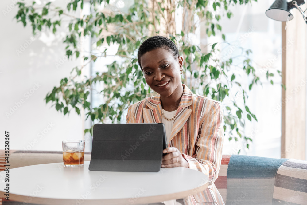 Smiling female freelancer talking during video conference through digital tablet in coffee shop Smiling female freelancer talking during video conference through digital tablet in coffee shop