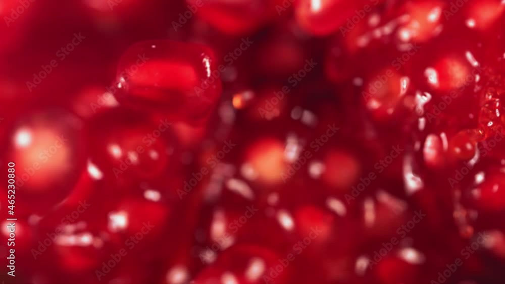Pomegranate Grains rolls down on surface of broken pomegranate in slow motion Pomegranate Grains rolls down on surface of broken pomegranate in slow motion