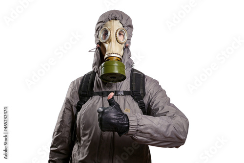 An isolated shot of a man dressed in a gas mask, a hooded jacket, a backpack, raised his thumb up, gesture ok, looking into the camera. On a white isolated background