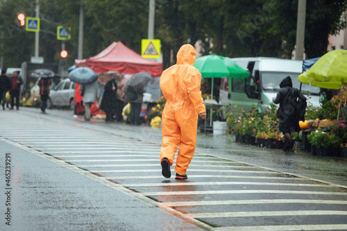 a man in a biosecurity suit on the street photo