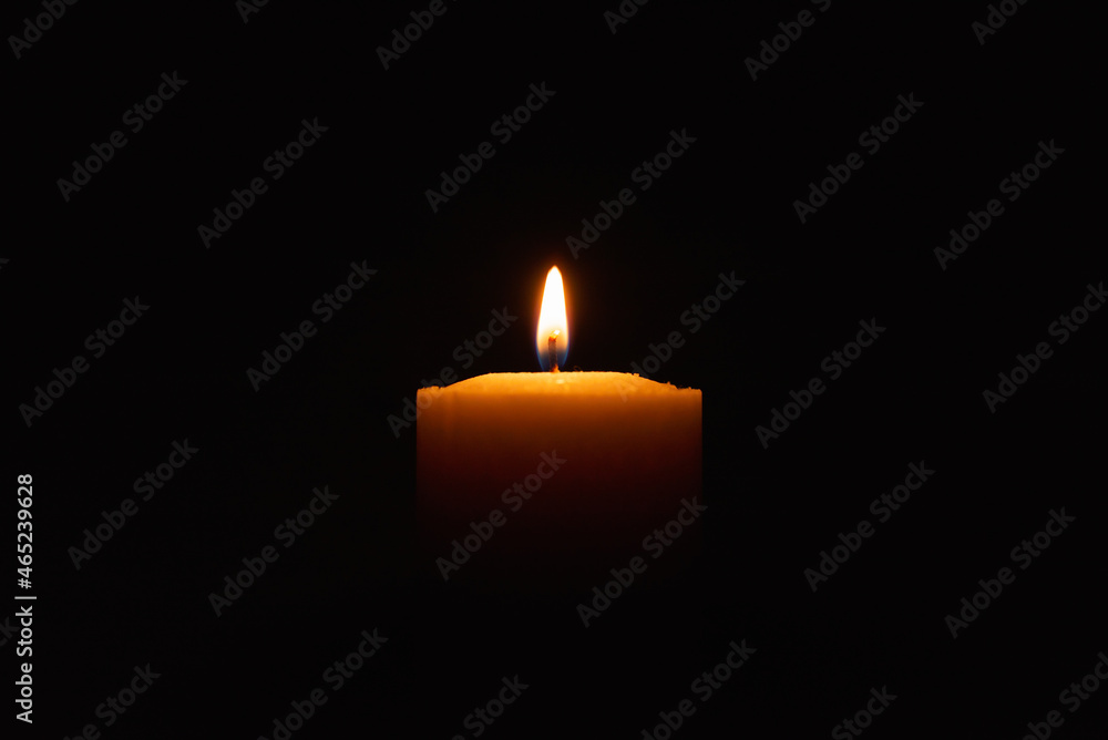 One single light candle burning brightly in the black background.Spiritual candle yellow flame. Flame of candle in the darkness.Copy space. One single light candle burning brightly in the black background.Spiritual candle yellow flame. Flame of candle in the darkness.Copy space.