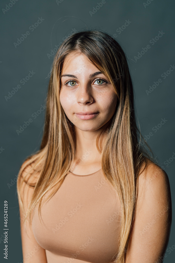 Young woman with long hair against gray background Young woman with long hair against gray background
