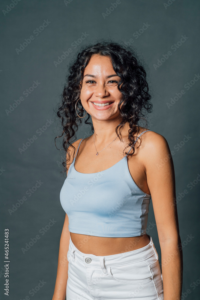Woman in casuals smiling against gray background Woman in casuals smiling against gray background
