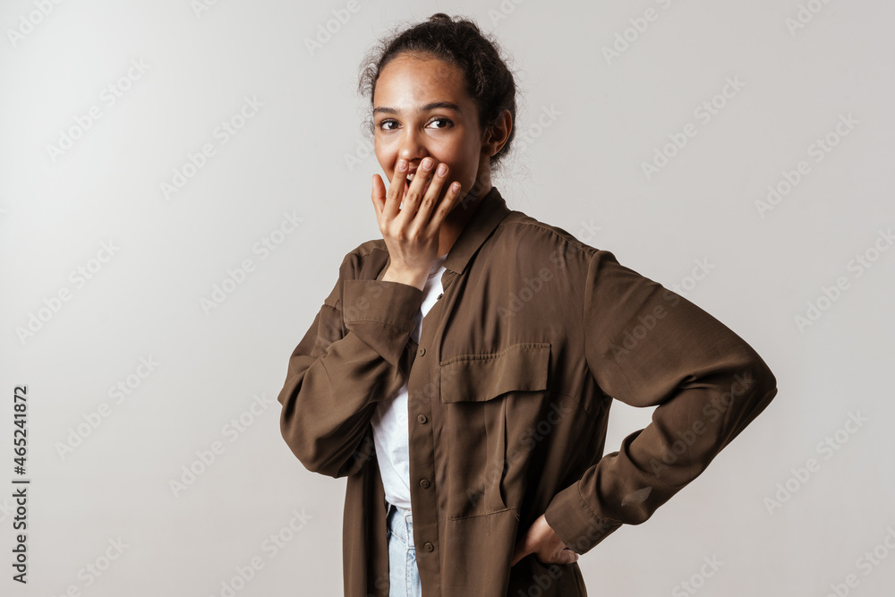 Young hispanic woman in shirt laughing and covering her mouth Young hispanic woman in shirt laughing and covering her mouth