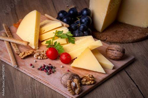 Kashar cheese or kashkaval cheese on wood floor. Cheese slices on the serving board (Turkish name; Kars Kasari) photo