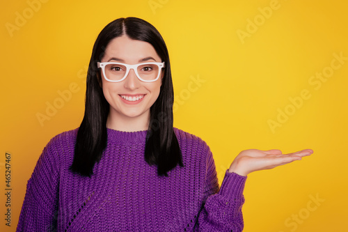 Photo pretty young girl lady happy positive smile point index finger empty space advert advice isolated yellow color background