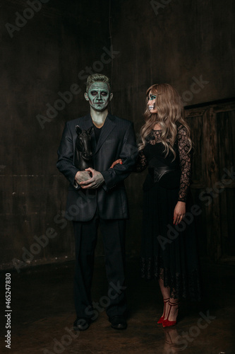 The image of a skeleton girl and the image of a Frankenstein man on Halloween in the dark. an image for a couple on Halloween. they stand next to each other in full height, a woman looks at a man