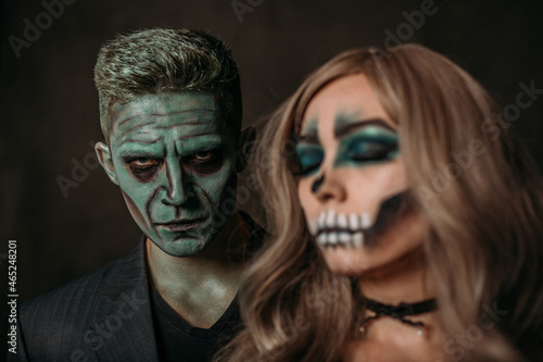 The image of a skeleton girl and the image of a Frankenstein man on Halloween in the dark. Paired image for Halloween. the man looks viciously at the camera