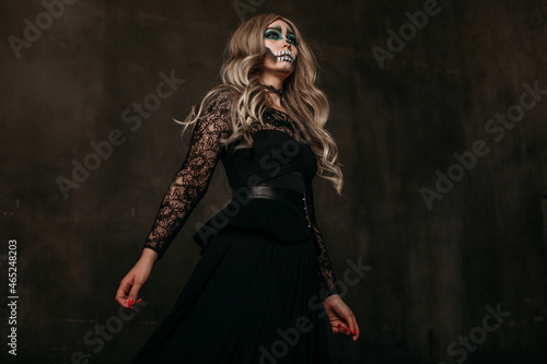 The image of a skeleton girl for Halloween. Female image for Halloween. The image of a skeleton girl for Halloween. Female image for Halloween. the woman has long blonde wavy hair, a lace black dress