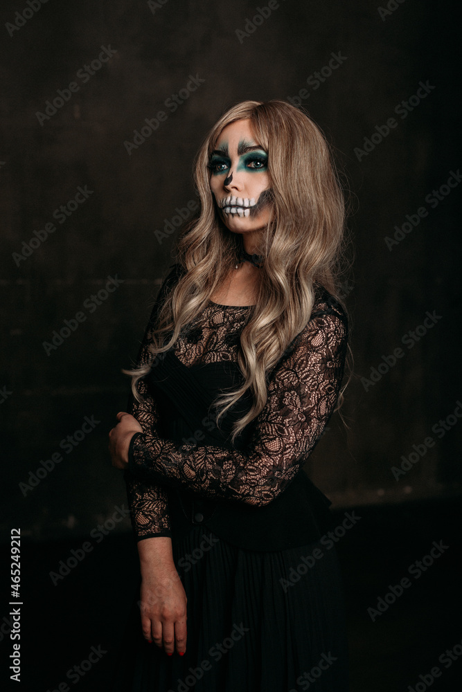 The image of a skeleton girl for Halloween. Female image for Halloween. the woman has long blonde wavy hair, a lace black dress The image of a skeleton girl for Halloween. Female image for Halloween. the woman has long blonde wavy hair, a lace black dress