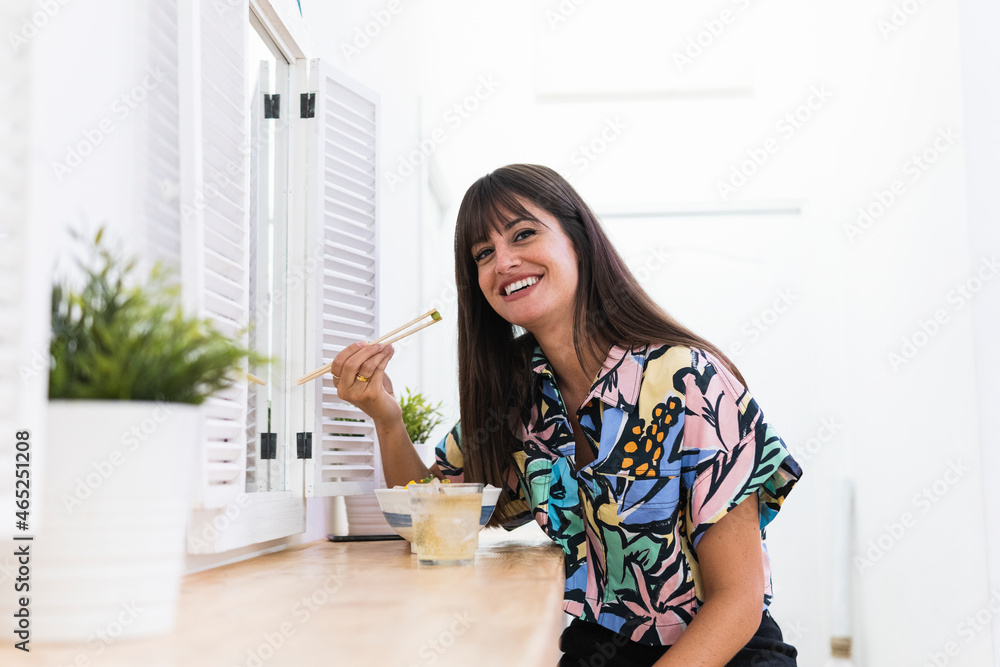 Smiling woman having food while sitting in restaurant Smiling woman having food while sitting in restaurant