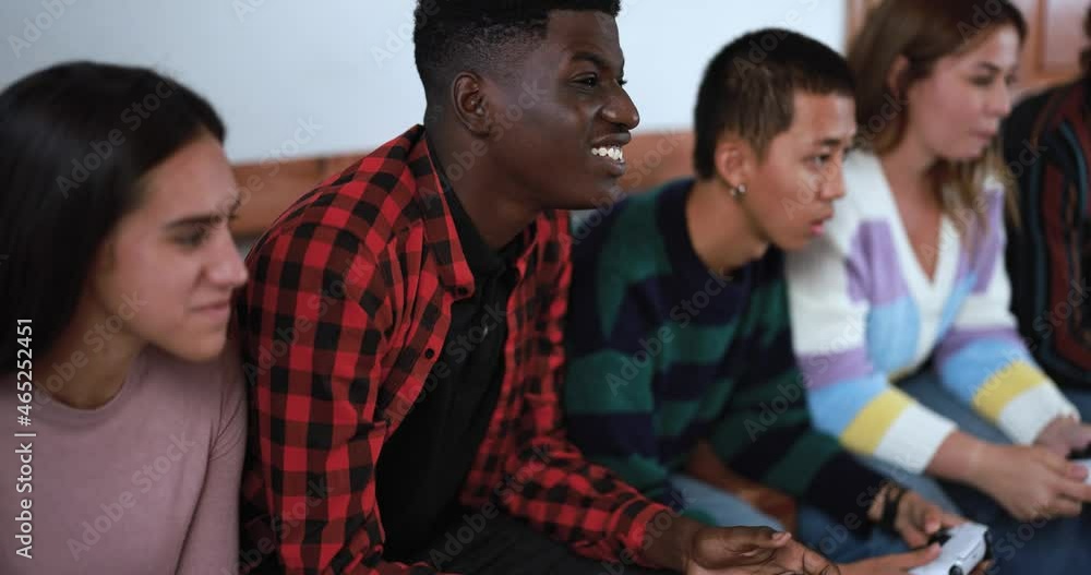 Group of multiracial friends playing with video games at home - Technology and generation z people concept Group of multiracial friends playing with video games at home - Technology and generation z people concept