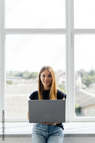 Young pretty woman with a laptop on the windowsill Free Download Young pretty woman with a laptop on the windowsill - GFXLoad