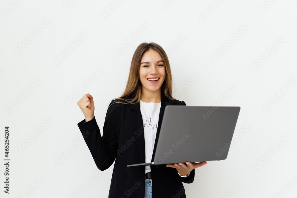 young beautiful business woman having an laptop in hands, leaning on a white wall young beautiful business woman having an laptop in hands, leaning on a white wall