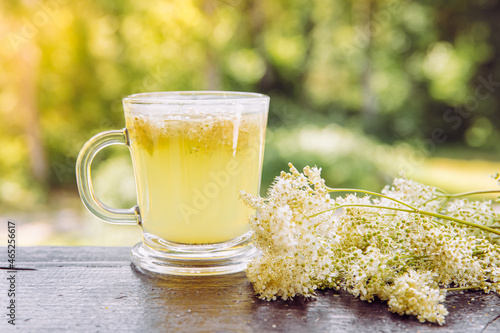 Fotografie Fresh Meadowsweet, Filipendula ulmaria flowers tea infusion in tea cup and fresh picked flower next to it