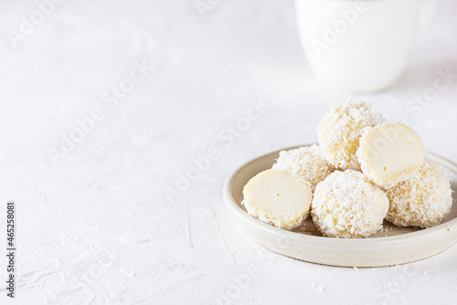 Vegan coconut truffles on a light table. Sugar, lactose and gluten free. Horizontal orientation, copy space.