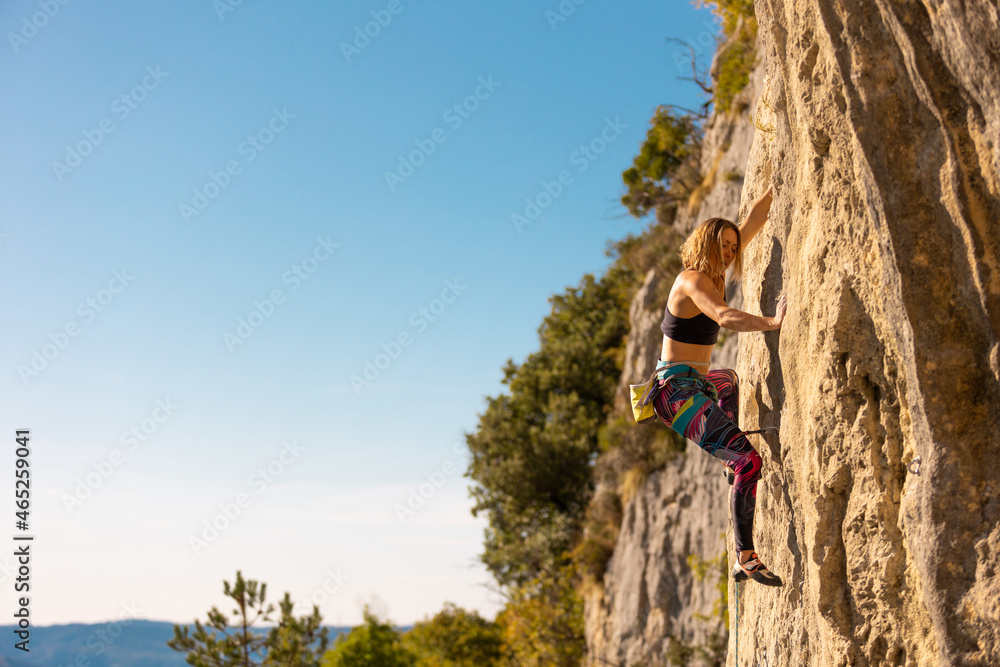 The girl climbs the rock.