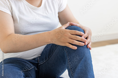 座って膝を押さえている女性（日本人、30代、顔無し）