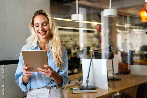 Portrait of an attractive young businesswoman smiling working on digital tablet in office