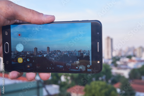 Taking photos of the city with the cell phone in hand