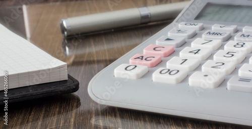 Calculator, pen and memopad on the desk.  photo