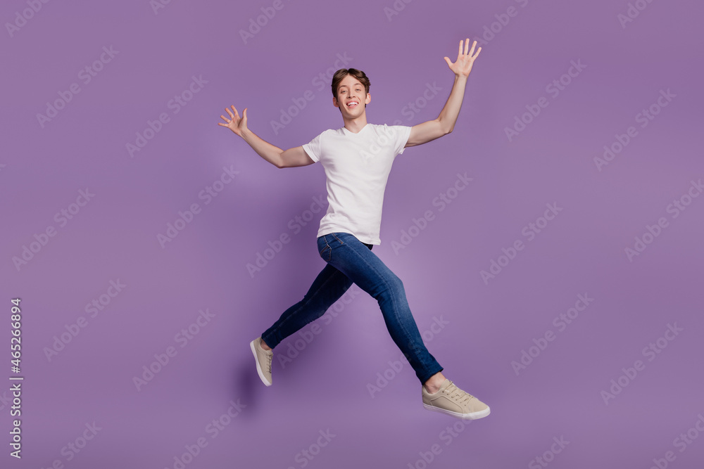 Fototapeta premium Full body profile side photo of young man good mood go walk run jump isolated on violet color background