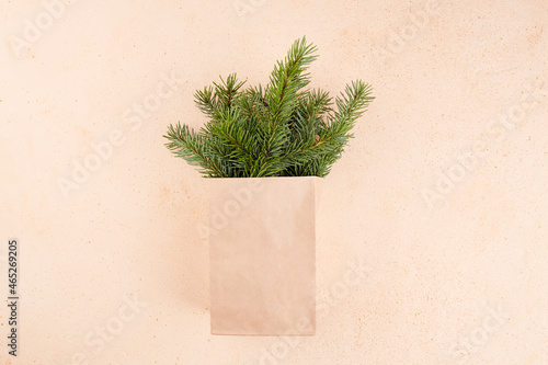 Winter bouquet of fir branches in a craft bag. Eco-friendly packaging in craft paper. Zero waste. Copy space, top view.