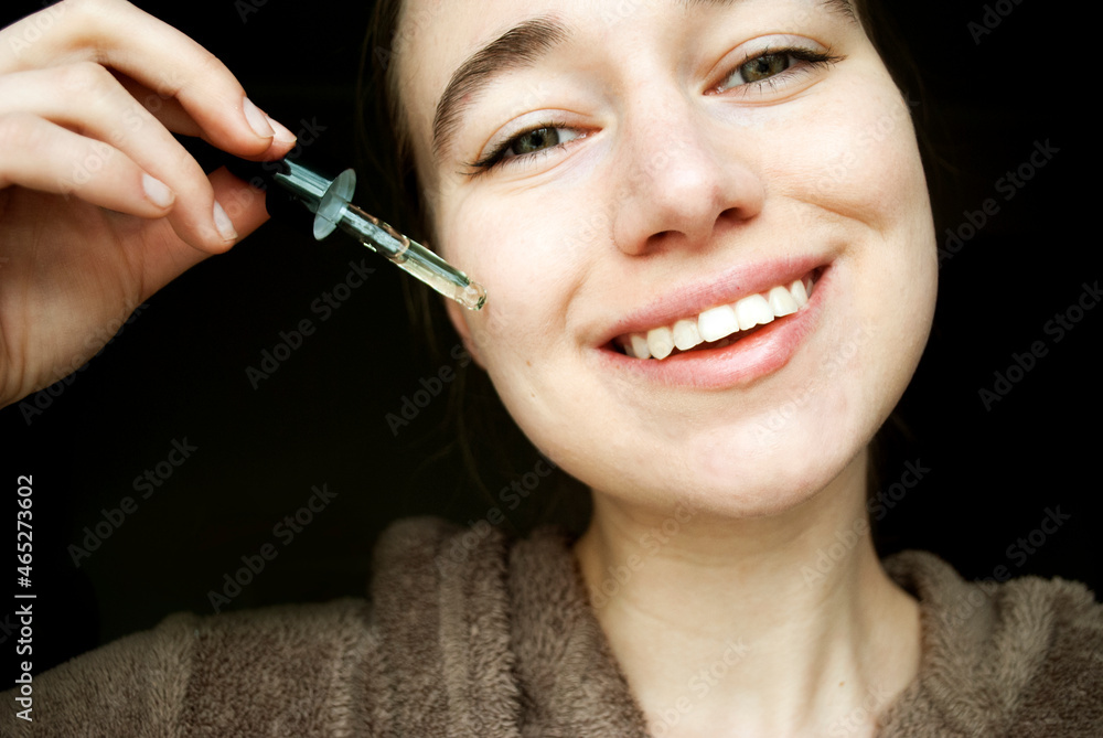 Beauty and skin care concept. Woman's face applying tea tree facial serum.
A beautiful young natural girl without makeup applies a serum to her face with a pipette. Beauty and skin care concept. Woman's face applying tea tree facial serum.
A beautiful young natural girl without makeup applies a serum to her face with a pipette.