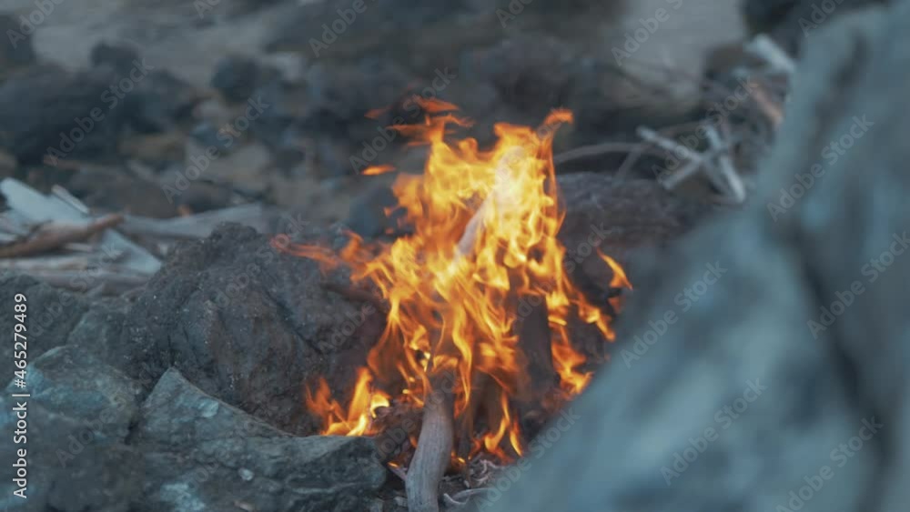 Rack focus campfire burning on rocky seaside shoreline 4K Rack focus campfire burning on rocky seaside shoreline 4K