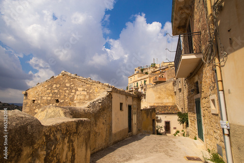 City landscape of old Sicilian Modica city. Sandstone houses, stairway and balconies, courtyards with nobody inside. Bright sunny photo good for touristic booklets, travel company website etc.