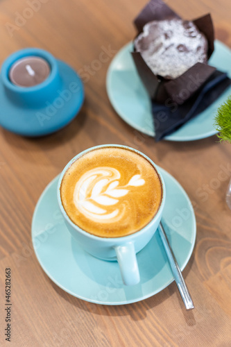 Latte art with cake on wooden table