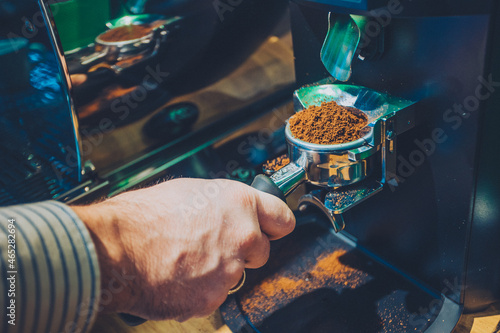 Fresh roasted grinded coffee falling from grinding machine