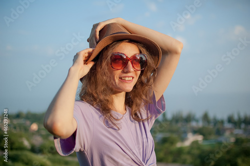 Young girl in dress is having great time during vacation in the summer on sky background in nature, travelling concept © Ольга 